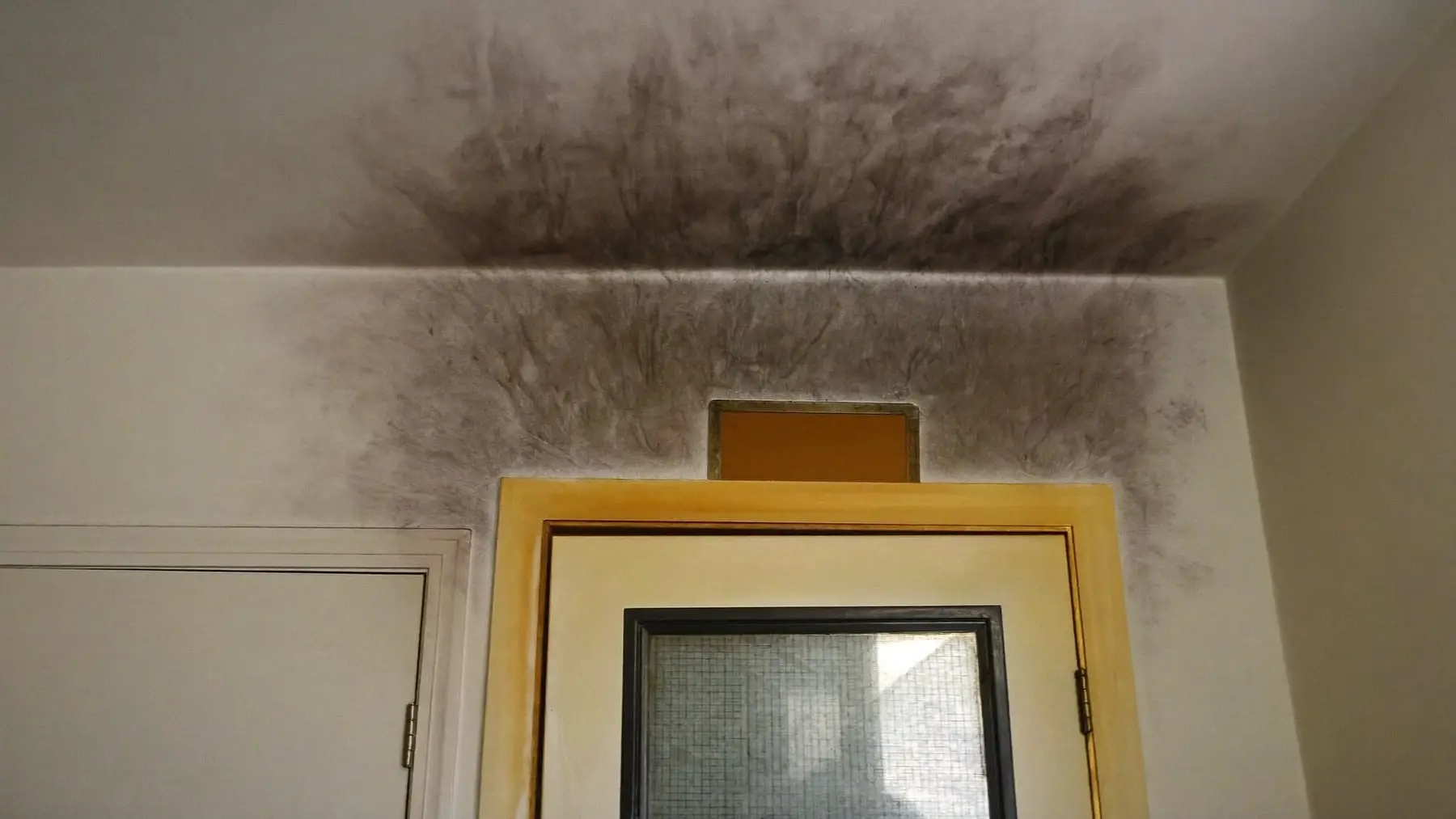 Smoke residue staining a wall and ceiling above a doorway